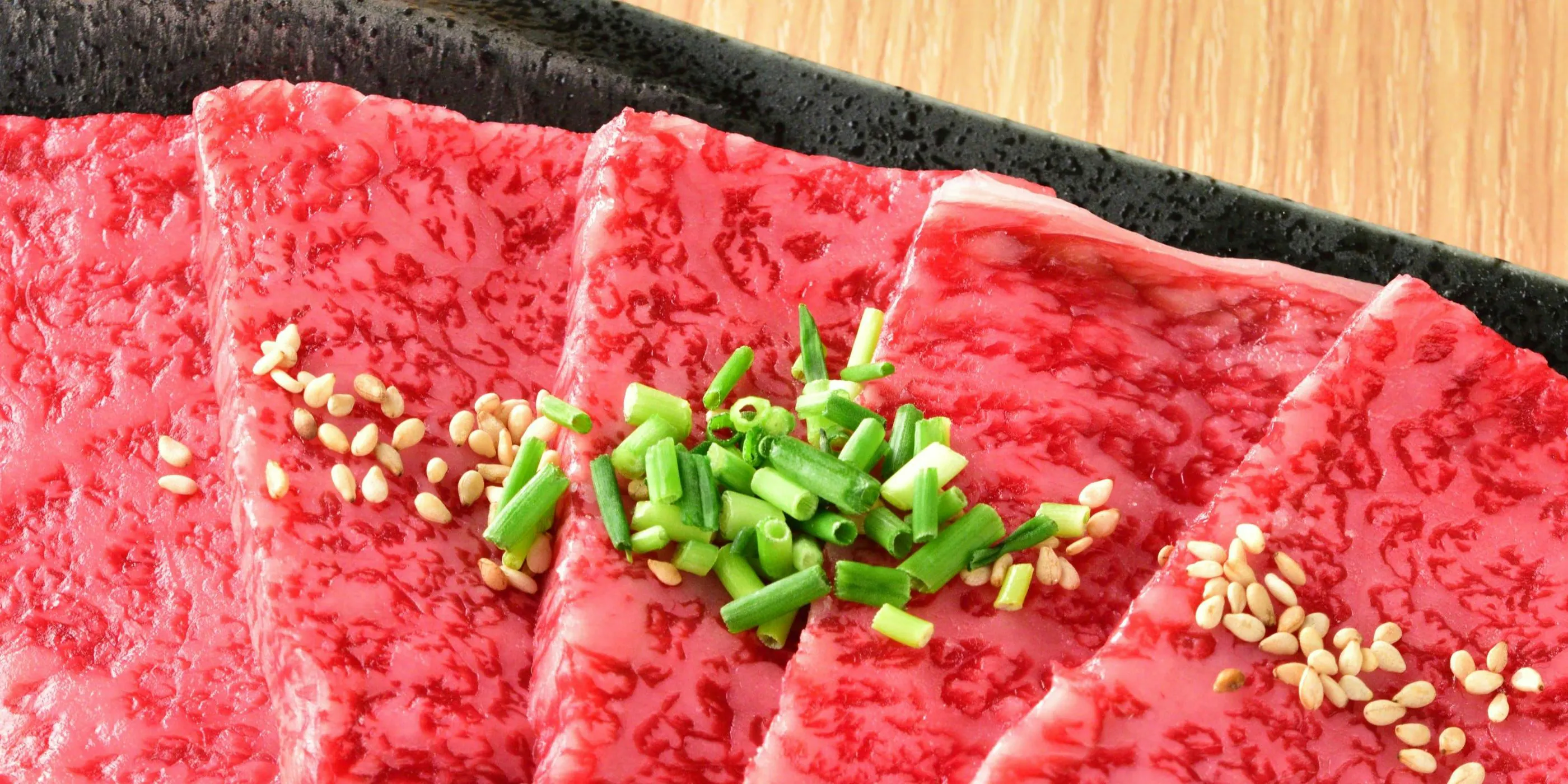 細かな霜降りの近江牛の薄切り、青ねぎと胡麻を添えて